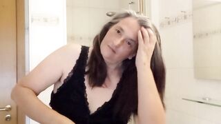 Mature woman with real silver strands slowly combs her long hair